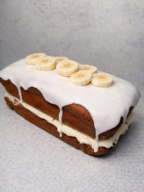 Banana loaf with white icing and fresh banana slices